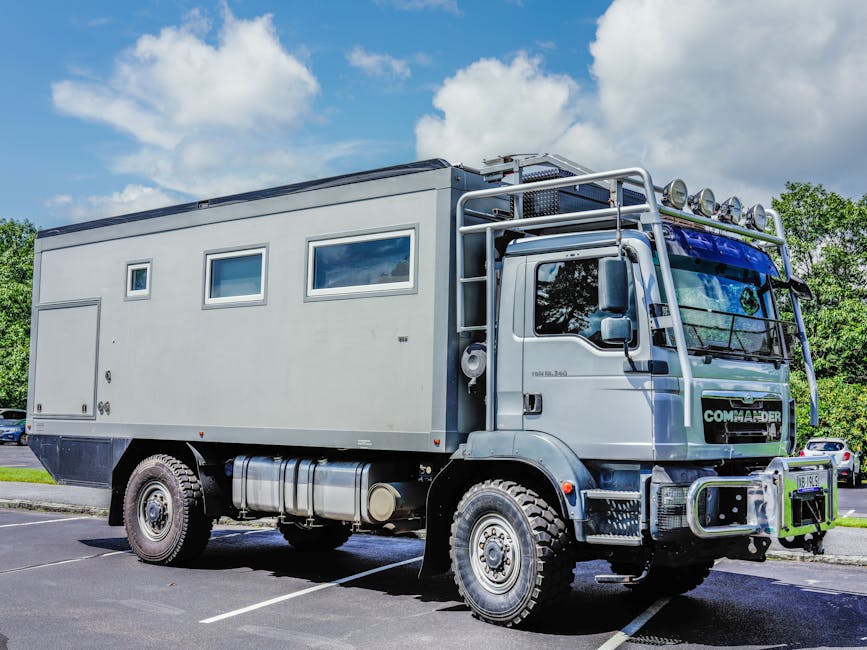 A rugged expedition vehicle parked outdoors under a clear blue sky