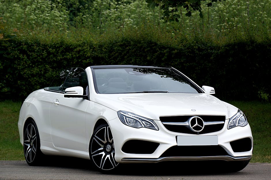 White Mercedes Benz convertible parked outdoors on a sunny day, showcasing luxury and style